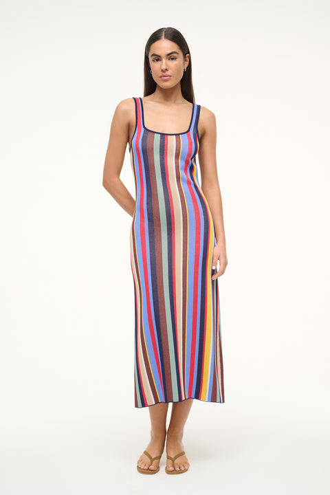 Woman wearing a knit midi dress that features a square neck and a colorful stripe patter, paired with tan sandals. 