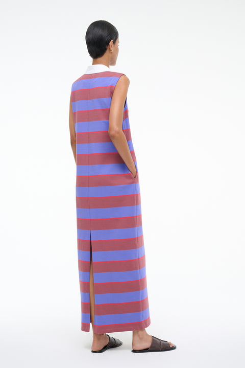 Back-facing woman wearing a sleeveless dress with red and blue horizontal stripes on a white background