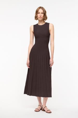 Woman wearing a sleeveless brown midi dress with brown sandals