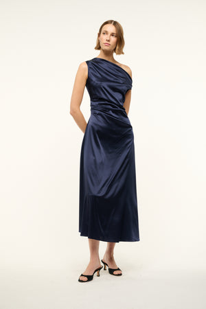 Woman wearing an asymmetrical navy silk midi dress. 