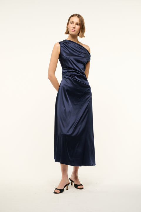 Woman wearing an asymmetrical navy silk midi dress. 
