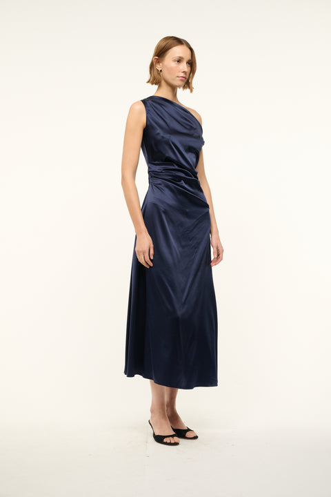 Woman wearing an asymmetrical navy silk midi dress. 