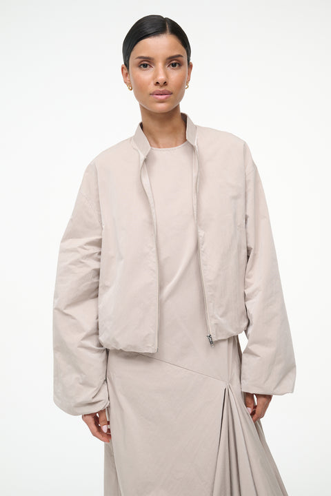 Woman wearing a beige outfit on a white background