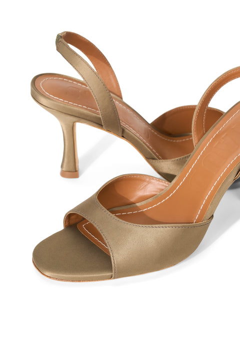 Pair of gold high-heeled sandals on a white background