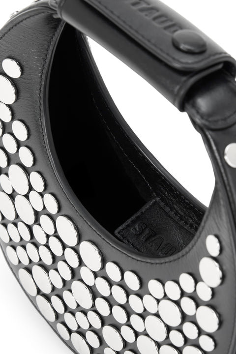 Detail shot of a black studded mini handbag. 