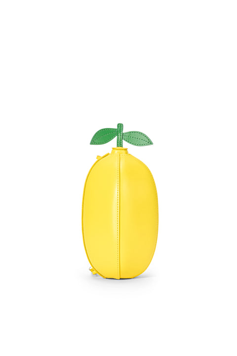 Yellow lemon-shaped clutch with a green leaf on a white background