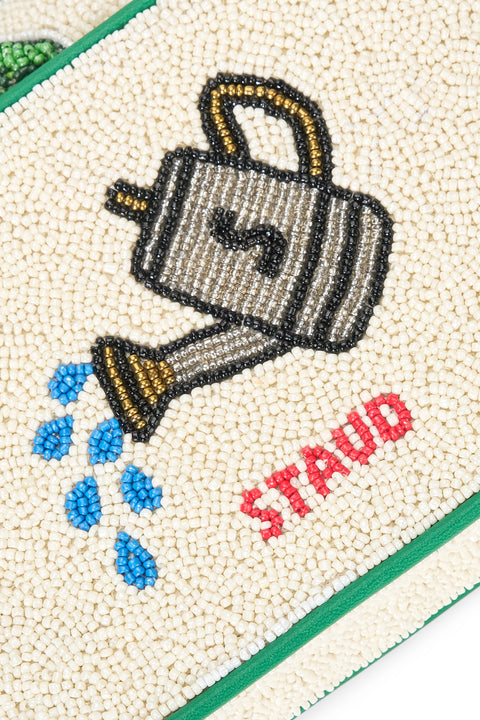 Beaded design of a watering can with 'STAUD' text on a textured surface