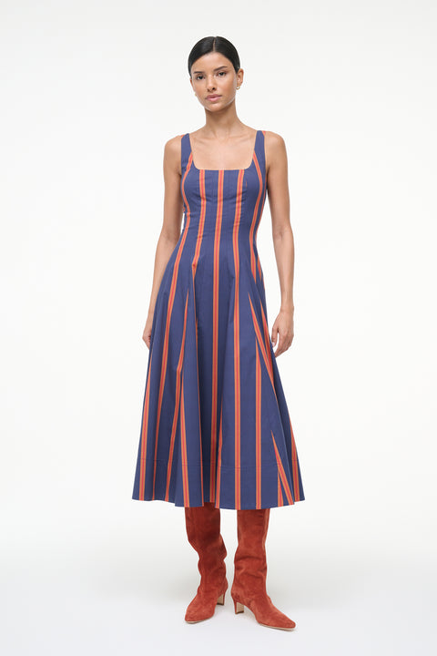 Woman wearing a blue and orange striped sleeveless midi dress with auburn suede boots. 
