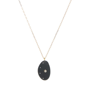 A cresent-shaped black stone, embellished with a round diamond and accented by a curve of smaller diamonds, further enhancing the crescent shape of the stone, all suspended on a yellow gold paperclip chain. 