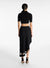 Model facing the back in the black asymmetric midi skirt