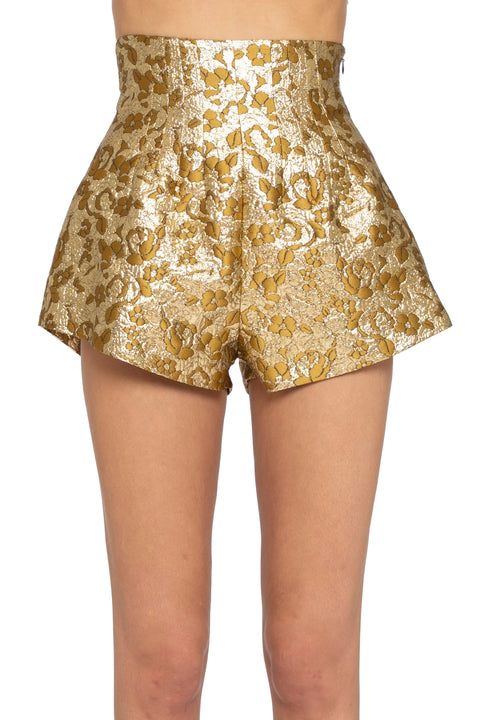 Gold metallic shorts worn by a person on a white background