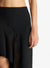 Close up of the black asymmetric midi skirt on a model