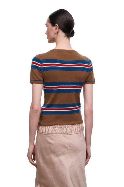 A woman shown from the back wearing a brown short-sleeve knit top with horizontal blue, red, and white stripes, paired with a beige skirt, against a plain white background.