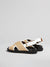 Back view of the fussbett sandals in black and white leather with raffia-effect .