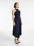 Model turned towards the right in the navy midi dress with crossover halter neckline