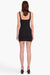 Model facing the back in the black mini dress
