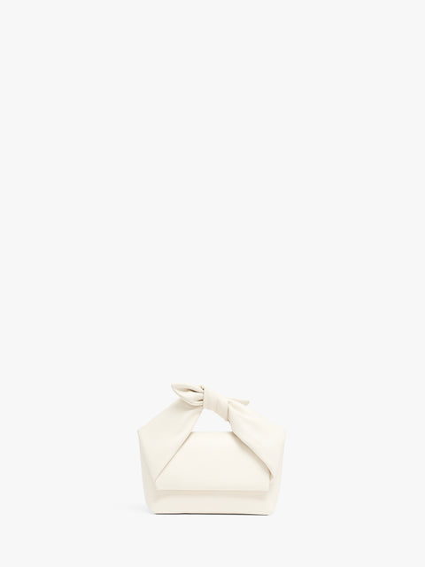 White leather top handle bag with knot at handle.