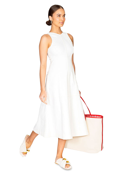 Model walking to the right showing the side of the arlet white midi dress.