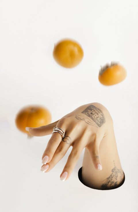 A woman's hand wearing a Spinelli Kilcollin Tigris MX ring. 