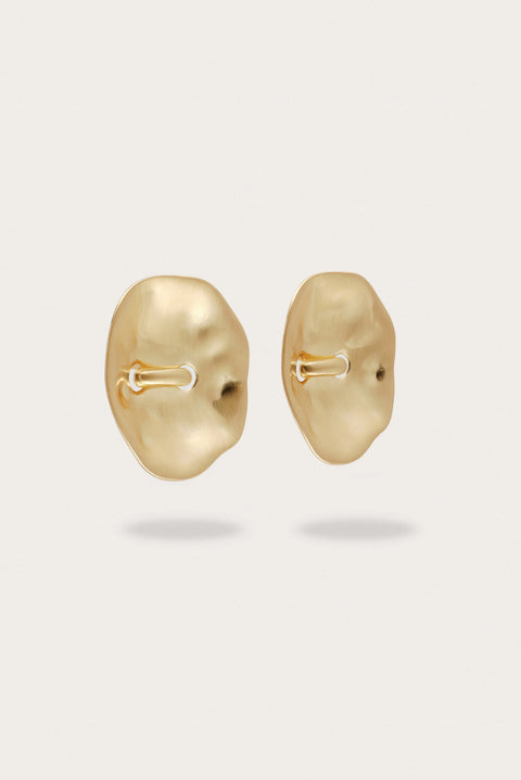 Pair of gold oversized earrings on a white background from the side view.