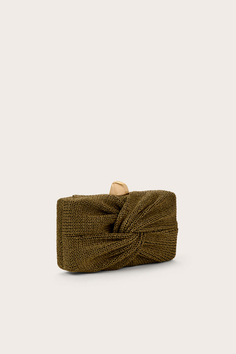 Side view of a dark green clutch that features a knotted straw detail and abstract gold hardware. 