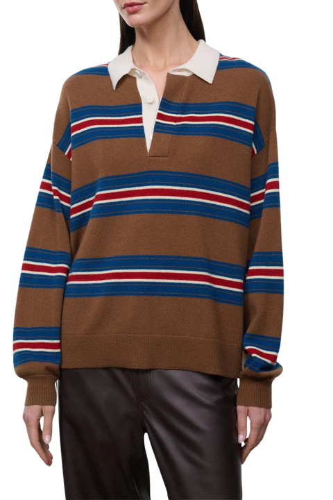 A woman wearing a brown knit polo sweater with horizontal blue, red, and white stripes, paired with black leather pants, against a plain white background.
