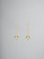 Ghost image of gold earrings with enamel penguin charm.