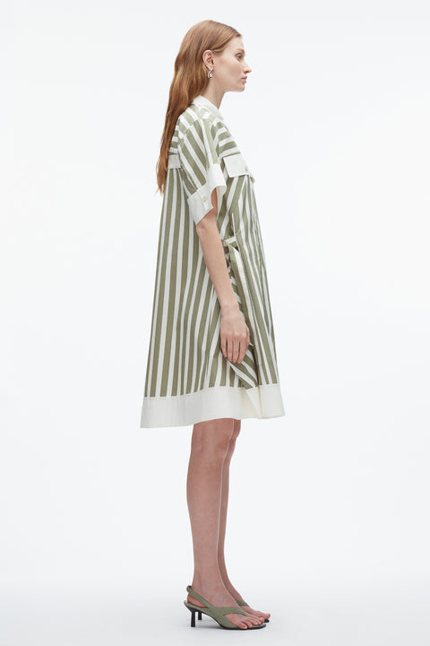 Side view of woman in green striped mini dress with white hemmed sleeves and hem.