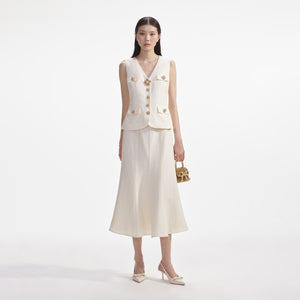 Model wearing the cream linen midi dress with large gold and pearl buttons.