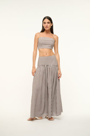 Woman wearing a brown gingham maxi skirt with a matching crop top. 