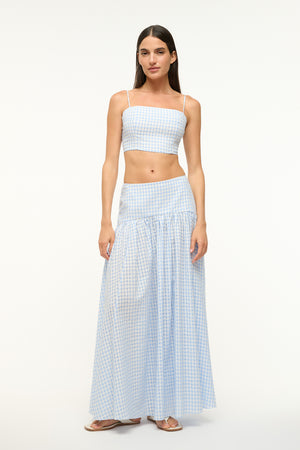 Woman wearing a blue gingham maxi skirt with a matching crop top