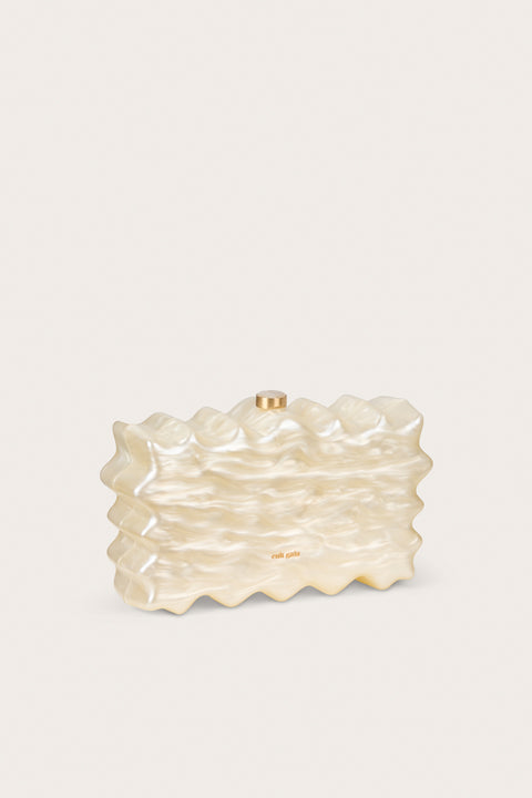 Side angle of a wavy, rectangular clutch made of pearlized acrylic, featuring gold hard wear. 