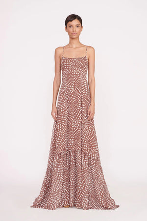 Full body view of a model facing the camera in the brown wavy dot print gown