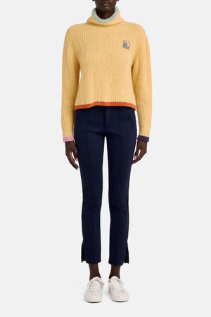 Model facing the camera in the yellow wool sweater with multi pastel trim