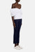 Full body view of a model turned towards the right in a white blouse and the navy pants