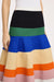 Very close look at the fabric and color paneling on the multicolor stripe midi skirt worn by a model