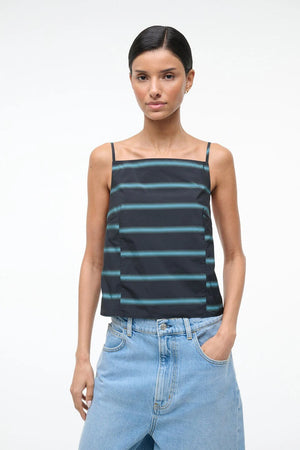 Woman wearing a striped tank top and jeans on a white background