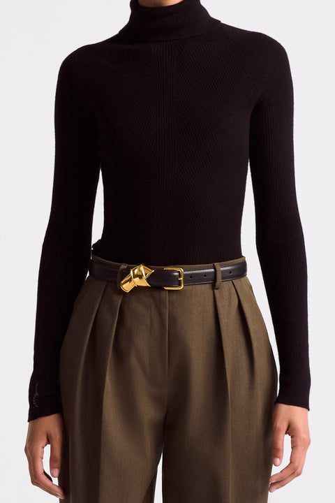 Model styled wearing the black leather belt with gold hardware.