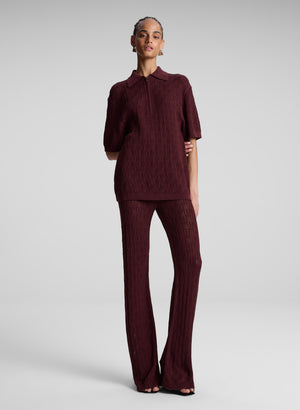 Model wears matching burgundy set with knit top and knit flared bottoms'