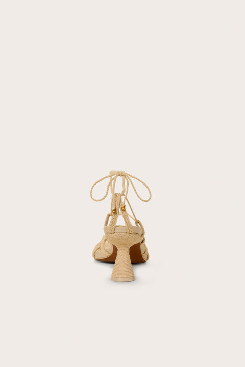 Back-facing raffia heel that features a gladiator-style lace up design with a unique comma heel. 