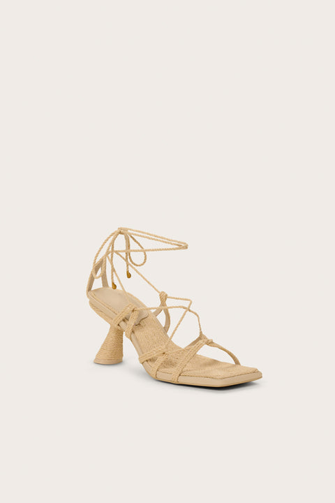 Front-facing raffia heel that features a gladiator-style lace up design with a unique comma heel. 