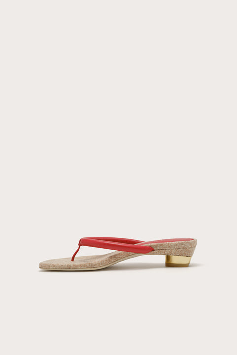 Sandal with a red thin strap on a white background from the mirrored side angle.
