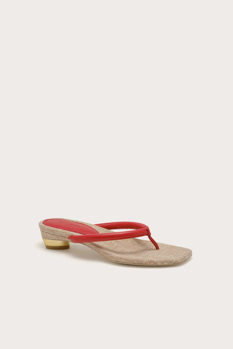 Sandal with a red thin strap on a white background placed at an angle.
