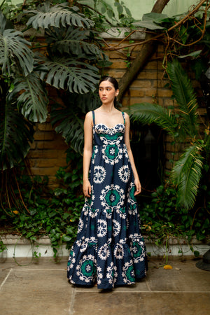 Model wearing the midi dress in front of foliage.