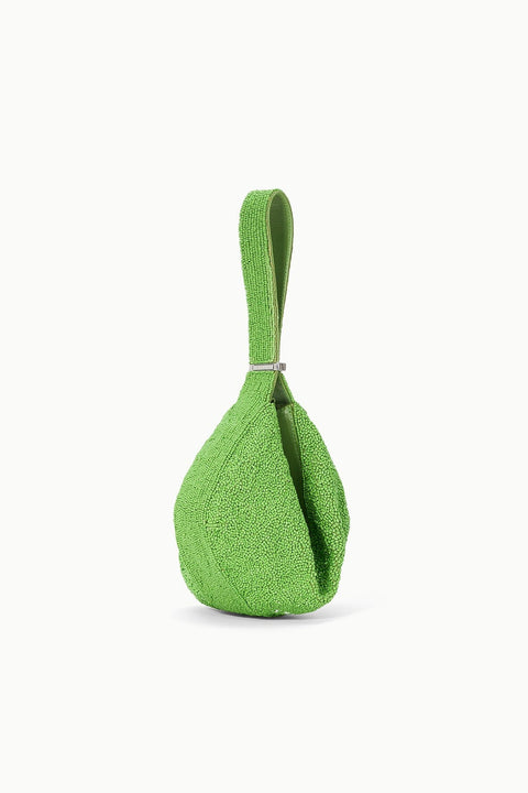 Side view of a green beaded handbag that has the strap fastened together to bring the handbag in on itself and create a unique drop shape. 