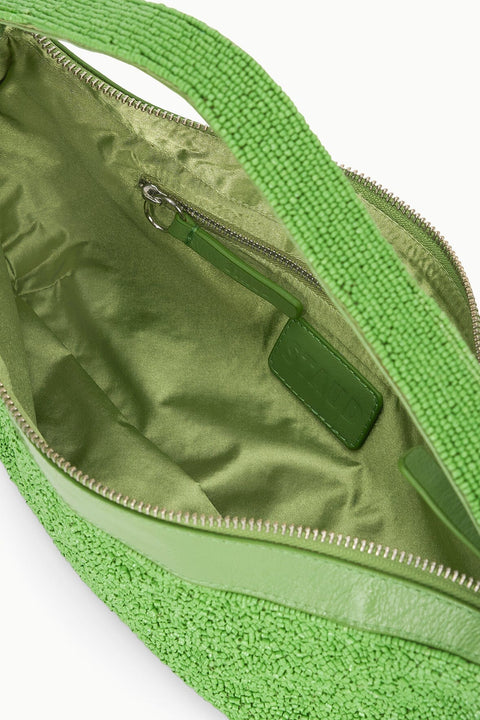 Inside shot of a green beaded handbag with green lining and an inner pocket with a zipper closure. 