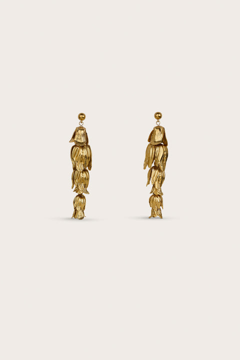 A pair of gold-toned drop earrings that resemble antique brass flowers. 