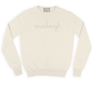 Cream crewneck sweater with "sourdough" hand stitched on the chest in sand colored thread.