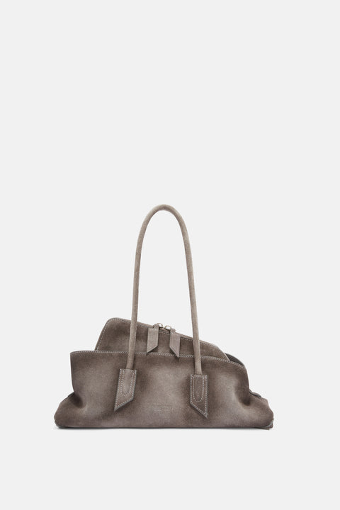 A grey, brushed suede, asymmetrical shoulder bag that features a shoulder strap and a peek-a-boo inside pouch with silver hardware. 