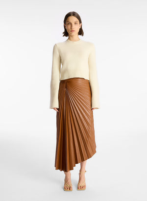 Model facing the camera in the brown vegan leather midi skirt with a cream sweater